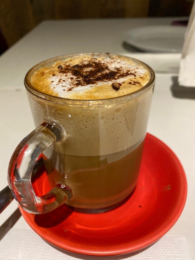 Cappuccino dusted with cocoa in a glass cup