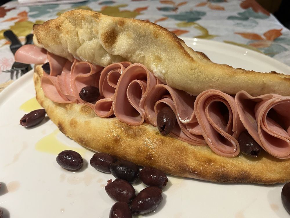 Pizza-bread sandwich filled with mortadella, with black olives